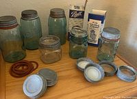 Full set of antique blue glass Ball Mason jars in various sizes, with zinc lids, sealing rings, and original boxes for packing.