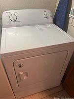 Front angle showing the white Roper dryer with a front door and basic top control panel.