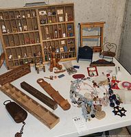 Overview of printers drawer with miniatures on table alongside small shelves, chairs, bead ornaments and trays