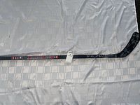 Full length view of black hockey stick with Brampton Beasts branding and overall condition shown