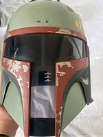 Front view of helmet showing T-visor, red and green paint with weathering chips