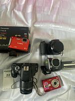 All four cameras displayed together with Panasonic box and camera manuals.