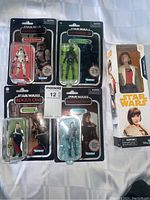 Front view of five sealed Star Wars figures featuring vintage style cardbacks for four figures and boxed Qi'ra figure