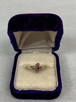 Ring shown in purple velvet jewelry box on cream cushion, highlighting overall size and presentation.