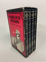 Front view of slipcase with four navy blue gilt-tooled hardcover books inside.