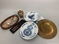 Lot overview including brass plate, porcelain plates, Japanese vase, basket tray, and chopsticks