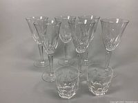 View of all items in the lot together showing two whiskey glasses in front and six goblets in back, showcasing shape and pattern