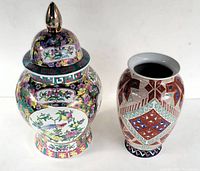 Two vases side by side, large covered Chinese porcelian jardiniere with floral and bird designs, smaller hand-painted porcelain vase with geometric patterns.