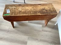 Top view of the vintage pine bench showing wear marks, scratches, and the hinged lid for storage opening.