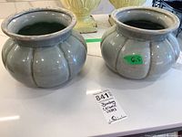 Two light gray Bombay ceramic vases with crackle glaze and bulbous shapes, shown side by side on table.