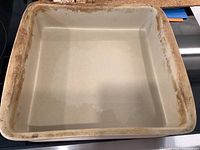 Top view of Pampered Chef 11x11 ceramic baker showing wear and discoloration on edges.