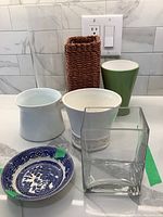 Photo showing six vases including glass, ceramic, a woven vase with glass insert, and a small blue and white Swinnertons Old Willow nappie plate with visible green tape on damaged areas.