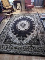 Full view of rug laid flat on hardwood floor showing overall pattern and condition