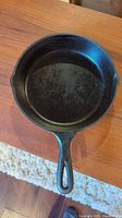 Top view of the 9-inch Lodge cast iron frying pan showing the smooth cooking surface and handle with hanging hole