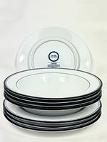 Stack of 4 plates with underside DANSK Concerto label showing made in Portugal and design details.