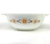 Side view of large white milk glass Pyrex Cinderella bowl with brown and gold Town & Country pattern showing exterior design and handles.