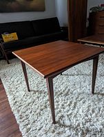 Side angled view of walnut mid-century modern square end table showing tapered legs and clean lines.