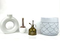 Four items on white backdrop showing planter, vases, and brass misting bottle