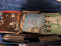 Full view of a large blue plastic bin packed with vintage vinyl records, some visible album covers such as Roy Haynes Country and others seen stacked vertically.