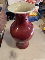 Full profile of oxblood glazed vase on table