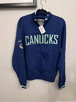 Front view of blue Vancouver Canucks Old Time Hockey sweatshirt with CANUCKS text and team logo on sleeve