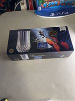 Box of the Longchamp Cristal D'arques set of 4 lead crystal wine glasses with violin image and product branding.