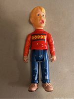Front view of the Home Alone action figure showing red sweater with diamond pattern, blue pants, and pink shoes.