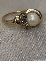 Front and side view showing the pearl and three natural diamonds mounted on the 10k yellow gold ring.