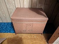 Closed record chest holder upholstered in brown vinyl with musical note design in studs on front.