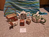 Image of the set showing all seven ceramic items on a carpet with a striped blue/green cloth background.