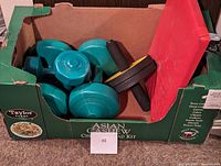 Box containing teal dumbbells and a black/yellow ab roller.