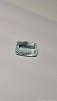 Single light blue aquamarine gemstone with barrel cut shown on white background