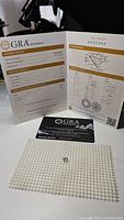 GRA grading report showing gem details and authenticity card with moissanite gemstone on pearl mat background