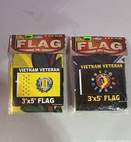 Two Vietnam Veteran flags 3'x5' still in original packaging, displaying the front design with yellow and black backgrounds.