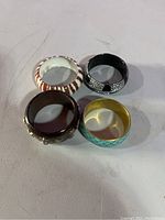 Four bracelets arranged in a square on a white surface showing color and pattern variety.