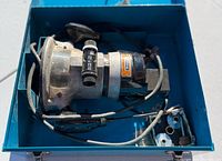 Metal-bodied Craftsman router with power cord folded inside the blue metal carrying case