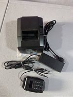 Full top-down shot of credit card reader and receipt printer with attached cables