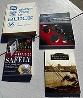 Photo displaying four books: Seventy Years of Buick, Single Cylinder OHV Air-Cooled Engines, Buy Gold and Silver Safely, and Rhode Island Shipwrecks.