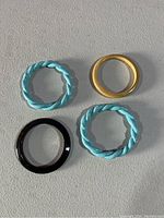 Top-down view of four bracelets placed on a flat surface showing color and material variety.