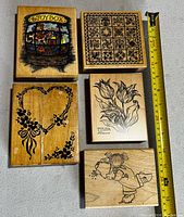 Top view of 5 wood block craft ink stamps showing design details with measuring tape beside for size reference.