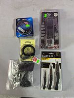 Top-down image of the miscellaneous lot showing the knife kit, knives, bracelet, cable ties, and fishing line