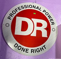 Front view of the round metal sign showing the DR Power Equipment logo and text