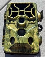 Close up image of camouflage wireless trail camera front showing lens and sensors.