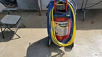 Full view of compressor with coiled yellow and blue hoses