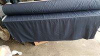 Bolt of dark navy fabric draped over a surface showing overall fabric color and width.