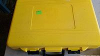 Yellow plastic carrying case, closed, rectangular shape with handle