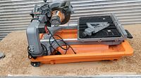 Side view of the full Ridgid R4040 tile saw showing frame, motor, and water tray.
