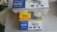 Three new traps in their original packaging: larger Havahart live animal cage trap, smaller Havahart live animal cage trap, and Victor electronic rat trap.
