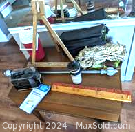 Overview of lot items on wooden table including easel, thermal jug, hat, and a few smaller items