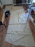 Full view of the inflatable mattress laid flat on the floor, along with the electric pump and some hospital bed frame parts visible around the edges.